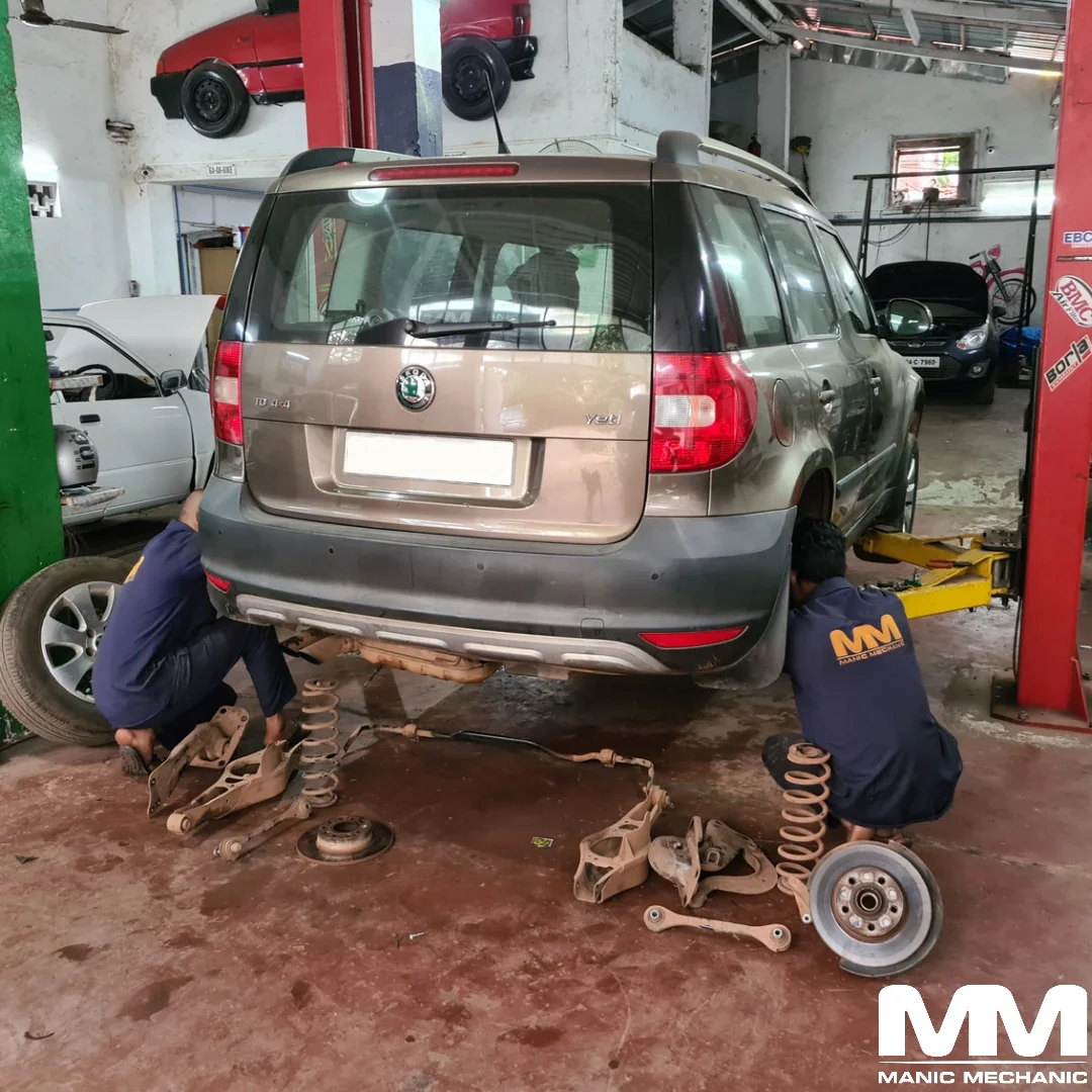 Suspension repair with dismantled rear suspension components at Manic Mechanic Goa